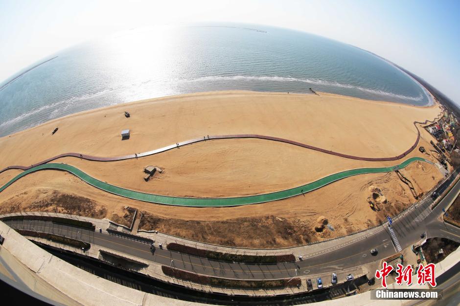 3月13日，秦皇島萬米臨海沙灘木棧道。據(jù)了解，該木棧道全長約4200米，與北戴河區(qū)原有的7500米木棧道對接后全線總長度1.17萬米，整個木棧道東起秦皇島體育基地游船碼頭，西至北戴河濕地公園，呈波浪形蜿蜒10.4公里海岸線。 中新社發(fā) 曹建雄 攝 CNSPHOTO